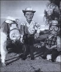 an old black and white photo of three children with horses in front of the camera