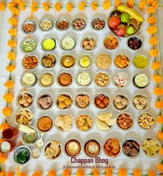 an arrangement of food is displayed on a table with orange flowers around the trays