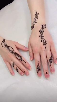 two hands with henna tattoos on them