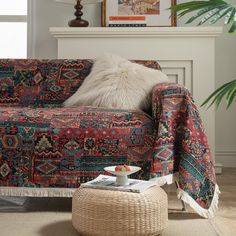 a living room with a couch covered in a colorful blanket and pillows next to a fire place