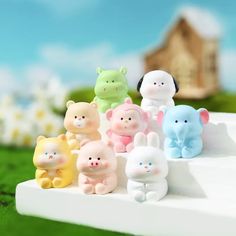 a group of small plastic animals sitting on top of a white bench in the grass