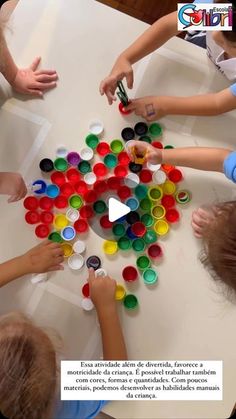 children are sitting at a table with cups and paint