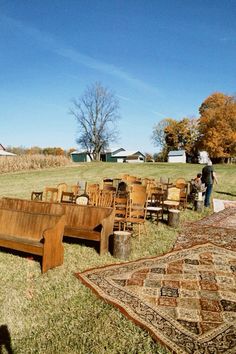 several wooden chairs and couches in an open field