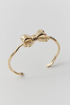 Bow cuff bracelet in polished metal. Open at the back for a personalized fit. Features Bow cuff bracelet Open back Content + Care Mixed metal Avoid contact with water Imported | Bow Cuff Bracelet in Gold, Women's at Urban Outfitters Coquette Jewelry, Preppy Accessories, Wishlist 2024, Bow Bracelet, Funky Jewelry, Jewelry Lookbook, Jewelry Outfit