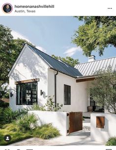 a white house with a metal roof and black shutters is featured in the new york times magazine