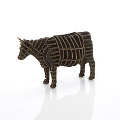 a wooden sculpture of a cow with stripes on it's body, standing in front of a white background