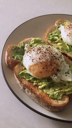 an egg and avocado toast is on a plate with some bread sprinkled with seasoning