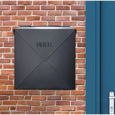 an email box mounted to the side of a brick wall next to a blue door