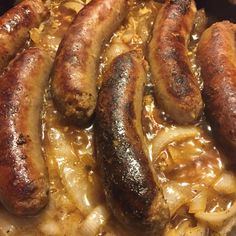 sausages and onions are being cooked in a skillet