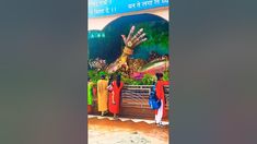 people are standing in front of a giant hand statue at the entrance to a temple