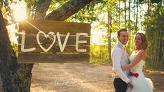 a man and woman standing in front of a love sign