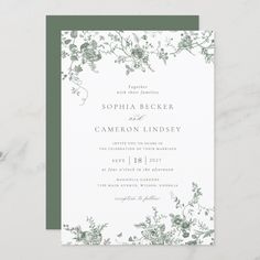 an elegant wedding card with green and white flowers on the front, featuring greenery