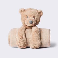 a teddy bear sitting on top of a pillow