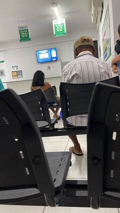 people sitting in chairs at an airport waiting for their luggage to be taken off the conveyor belt