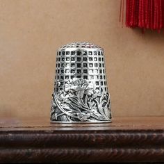 a silver thimble sitting on top of a wooden table