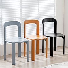 three chairs sitting next to each other in front of a window