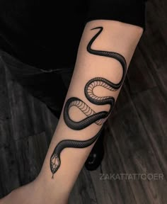 a woman's arm with a snake tattoo on it