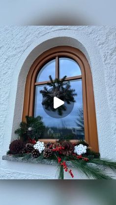 a christmas wreath sitting on top of a window sill