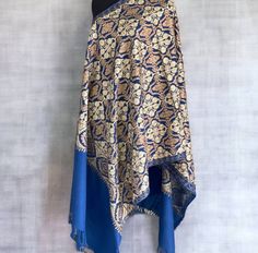 The fashionable pashmina shawl is handmade, a harmonious masterpiece combining beauty and practicality. This stunning shawl, carefully sewn, has a bright blue hue, radiating heat. The shawl is decorated with a charming floral pattern adorning the entire space of the shawl. Exquisite embroidery, decorated with rich shades of gold and bronze colors, gives elegance to the design of nature. This unique scarf is thoughtfully designed to seamlessly transform into a traditional hijab, wear it as a hijab or as a cape. Made of high quality light materials, the Hijab convertible is ideal for cool weather, offering you a cozy layer of heat while maintaining breathable. The soft touch of the fabric ensures that you will be comfortable throughout the day, regardless of the season. Designed for versatil Elegant Zari Work Shawl Scarves, Traditional Blue Hijab For Eid, Elegant Motif Scarves For Festive Occasions, Pashmina Shawl Scarf With Pallu, Elegant Scarves With Motifs For Festive Occasions, Elegant Festive Scarves With Motifs, Traditional Gold Pashmina Shawl For Eid, Traditional Pashmina Scarf Wrap, Festive Pashmina Scarf With Pallu