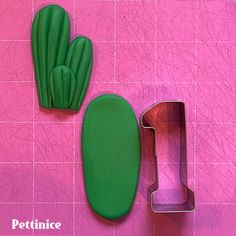 two cookie cutters sitting next to each other on a pink tile background with a green cactus