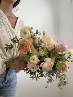 a woman holding a bouquet of flowers in her hands