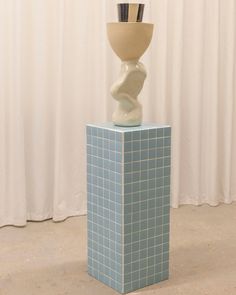 a vase sitting on top of a blue block