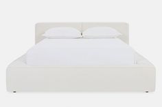 a white bed with two pillows on top of the headboard and one foot board