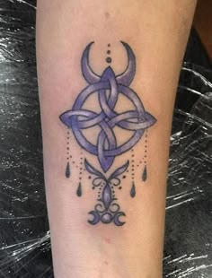 a tattoo on the leg of a woman with a crescent and stars in purple ink