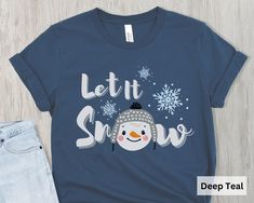 a t - shirt that says let it snow with a snowman wearing a hat