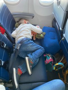 a small child sleeping on an airplane seat