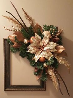 a christmas wreath is hanging on the wall next to a frame with gold and silver decorations