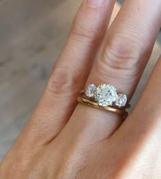 a woman's hand with three diamond rings on top of her finger and the other ring