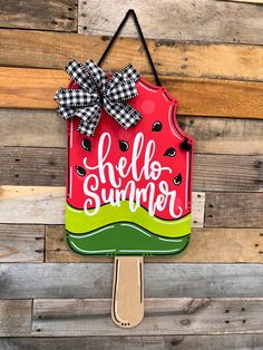 a wooden sign that says hello summer on top of a popsicle with a bow