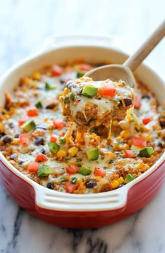 a spoon full of mexican chicken casserole on a marble counter