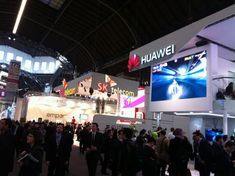 a large group of people standing around at a trade show