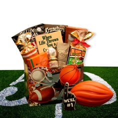 a sports themed gift basket on a football field with an orange basketball and other items