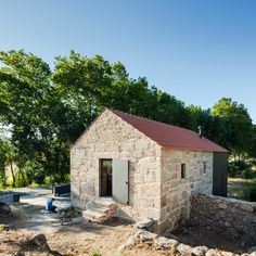 a small stone building with a red roof