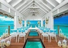 an outdoor wedding venue set up with blue and white decor on the water's edge