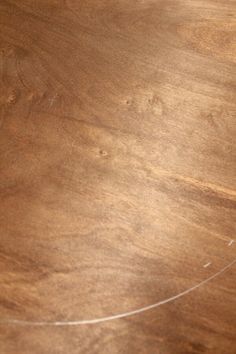 a close up view of a wooden table with white lines on it and the edge of the wood