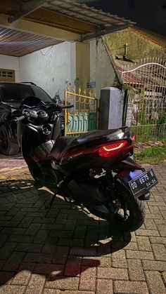 the motorcycle is parked on the side of the road next to the fence and gate