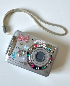 the camera is decorated with colorful jewels and bows on it's front side, as well as a lanyard