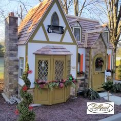 a doll house is decorated with christmas wreaths and garlanding on the windows, doors, and shutters