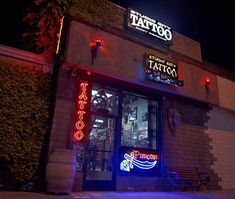 a taco restaurant with neon lights on the front and side of it at night