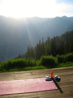 a yoga mat on a wooden deck overlooking the mountains