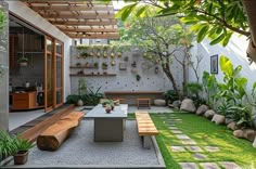 an outdoor patio with wooden benches and plants on the wall, surrounded by green grass