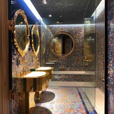 a bathroom with two sinks, mirrors and mosaic tiles on the wall in it's shower stall