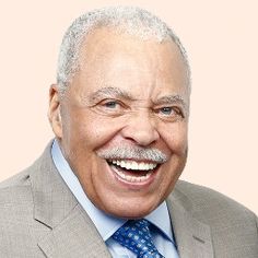 an older man wearing a gray suit and blue tie smiling at the camera with his mouth open