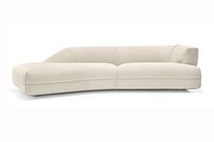 the curved sofa is white and has a long armrest on one end, and an extended