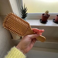 Natural, plastic-free bamboo hairbrush that's better for your hair This fully biodegradable, plastic-free bamboo hairbrush (even the pins are 100% bamboo!) will not damage the hair like a standard plastic pinned brush. It has completely smooth edges and cushioned bristles with rounded ends – perfect for gentle, nick free, detangling and will help create a sleek and shiny finish. Bamboo brushes create less static. Cue the science. Plastic brushes increase the electrical charge so as it slides through, the charge is transferred to your hair and you get static. Bamboo has a neutral charge, so static is reduced (or often disappears), which is basically much more ‘zen’ for your hair and allows it to lay down (or up) and chill. The cushioned bristles and rounded ends are perfect to stimulate and Bamboo Brush Aesthetic, Bamboo Hairbrush, Haircare Natural, Bamboo Hair Brush, Wooden Hair Brush, Bamboo Brush, Biodegradable Plastic, Smooth Edges, Natural Hair Care