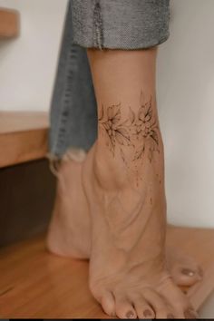 a woman's foot with flowers on it and the bottom part of her leg